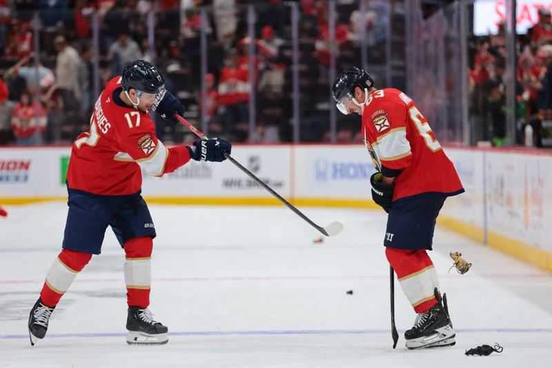 Nov 1, 2025; Sunrise, Florida, USA; Florida Panthers center Evan Rodrigues (17) shoots a rat against left wing Brad Marchand (63) after the game against the Dallas Stars at Amerant Bank Arena. Mandatory Credit: Sam Navarro-Imagn Images