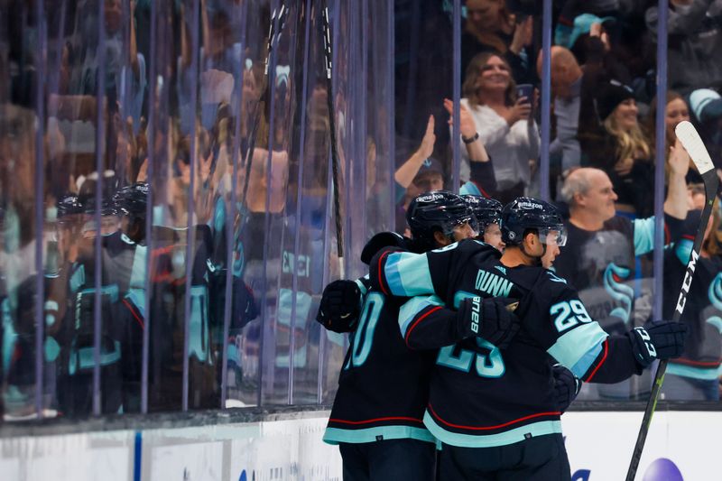 Oct 1, 2022; Seattle, Washington, USA; Seattle Kraken center Matty Beniers (10) celebrates with teammates, including defenseman Vince Dunn (29), after scoring a goal against the Vancouver Canucks during the second period at Climate Pledge Arena. Mandatory Credit: Joe Nicholson-USA TODAY Sports