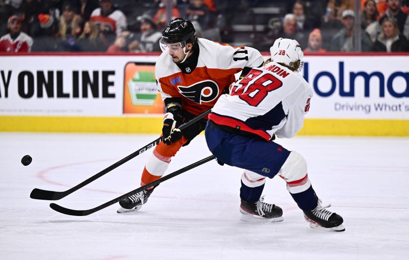 Dec 14, 2023; Philadelphia, Pennsylvania, USA; Philadelphia Flyers right wing Travis Konecny (11) reaches for the puck against Washington Capitals defenseman Rasmus Sandin (38) in the first period at Wells Fargo Center. Mandatory Credit: Kyle Ross-USA TODAY Sports