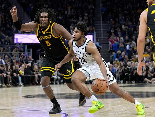 SAN FRANCISCO, CALIFORNIA - DECEMBER 16: Cam Thomas #24 of the Brooklyn Nets drives towards the basket on Kevon Looney #5 of the Golden State Warriors during the fourth quarter of an NBA basketball game at Chase Center on December 16, 2023 in San Francisco, California. NOTE TO USER: User expressly acknowledges and agrees that, by downloading and or using this photograph, User is consenting to the terms and conditions of the Getty Images License Agreement. (Photo by Thearon W. Henderson/Getty Images)