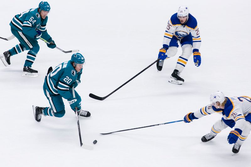 Nov 23, 2024; San Jose, California, USA; San Jose Sharks left wing Fabian Zetterlund (20) takes the puck down the ice as Buffalo Sabres defenseman Rasmus Dahlin (26) and defenseman Owen Power (25) defend during the third period at SAP Center in San Jose. Mandatory Credit: John Hefti-Imagn Images