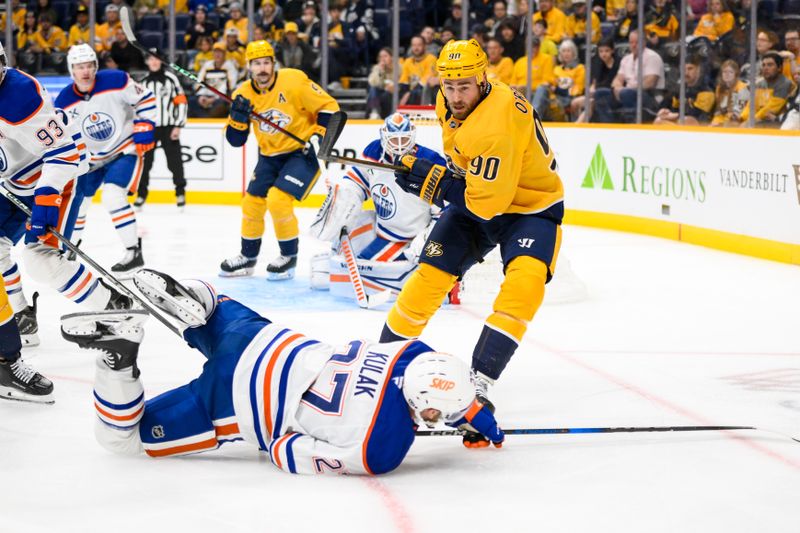 Oct 31, 2024; Nashville, Tennessee, USA; Nashville Predators center Ryan O'Reilly (90) checks Edmonton Oilers defenseman Brett Kulak (27)  during the first period at Bridgestone Arena. Mandatory Credit: Steve Roberts-Imagn Images