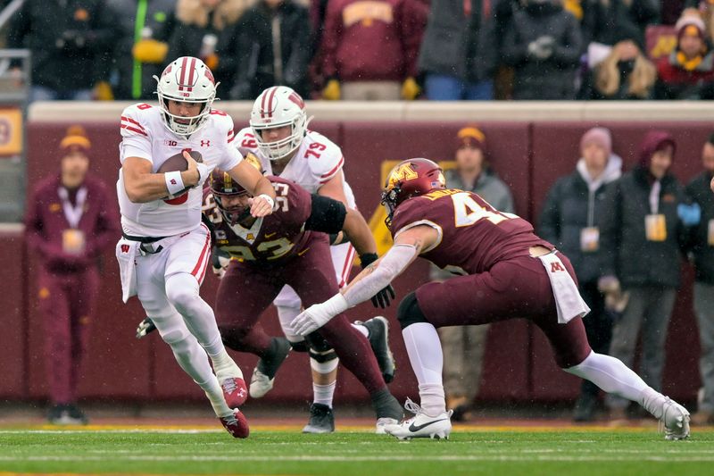 Nov 25, 2023; Minneapolis, Minnesota, USA;  Wisconsin Badgers quarterback Tanner Mordecai (8) runs with the ball as Minnesota Golden Gophers linebacker Cody Lindenberg (45) and defensive lineman Kyler Baugh (93) give chase during the first quarter at Huntington Bank Stadium. Mandatory Credit: Nick Wosika-USA TODAY Sports