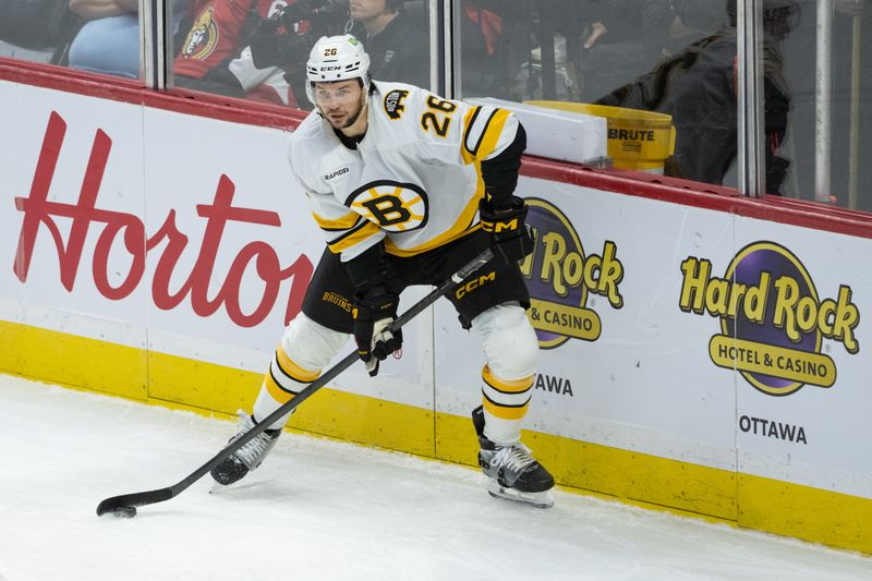 Oct 27, 2025; Ottawa, Ontario, CAN; Boston Bruins defenseman Andrew Peeke (26) controls the puck in the third period against the  Ottawa Senators at the Canadian Tire Centre. Mandatory Credit: Marc DesRosiers-IMAGN Images