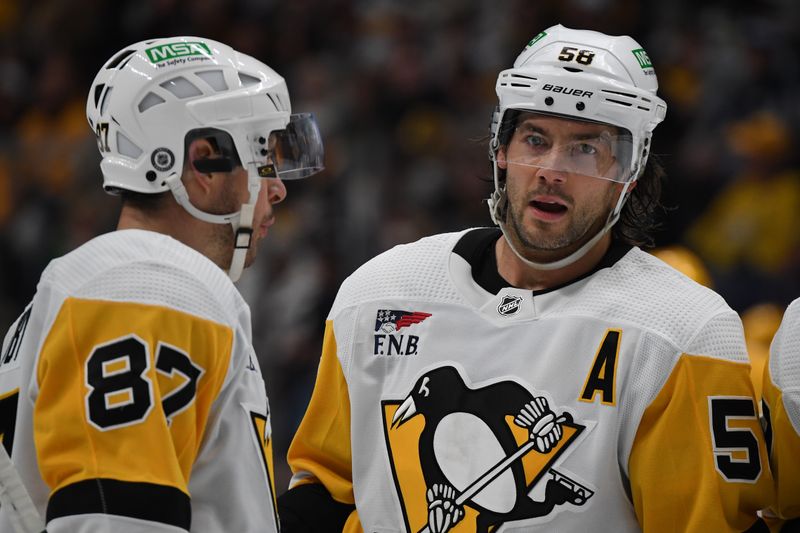 Nov 28, 2023; Nashville, Tennessee, USA; Pittsburgh Penguins defenseman Kris Letang (58) talks with Pittsburgh Penguins center Sidney Crosby (87) during the second period at Bridgestone Arena. Mandatory Credit: Christopher Hanewinckel-USA TODAY Sports