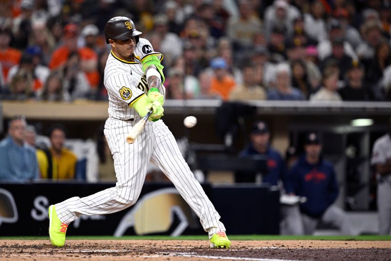 Sep 17, 2024; San Diego, California, USA; San Diego Padres third baseman Manny Machado (13) hits a two-run home run against the Houston Astros during the sixth inning at Petco Park. Mandatory Credit: Orlando Ramirez-Imagn Images