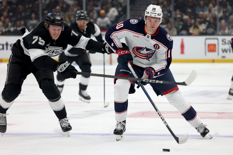 Nov 9, 2024; Los Angeles, California, USA; Columbus Blue Jackets left wing Dmitri Voronkov (10) keeps the puck from Los Angeles Kings center Samuel Helenius (79) during the third period at Crypto.com Arena. Mandatory Credit: Jason Parkhurst-Imagn Images