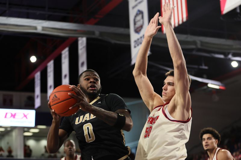 Jan 14, 2024; Boca Raton, Florida, USA; UAB Blazers forward Javian Davis (0) drives to the basket against Florida Atlantic Owls center Vladislav Goldin (50) during the first half at Eleanor R. Baldwin Arena. Mandatory Credit: Sam Navarro-USA TODAY Sports