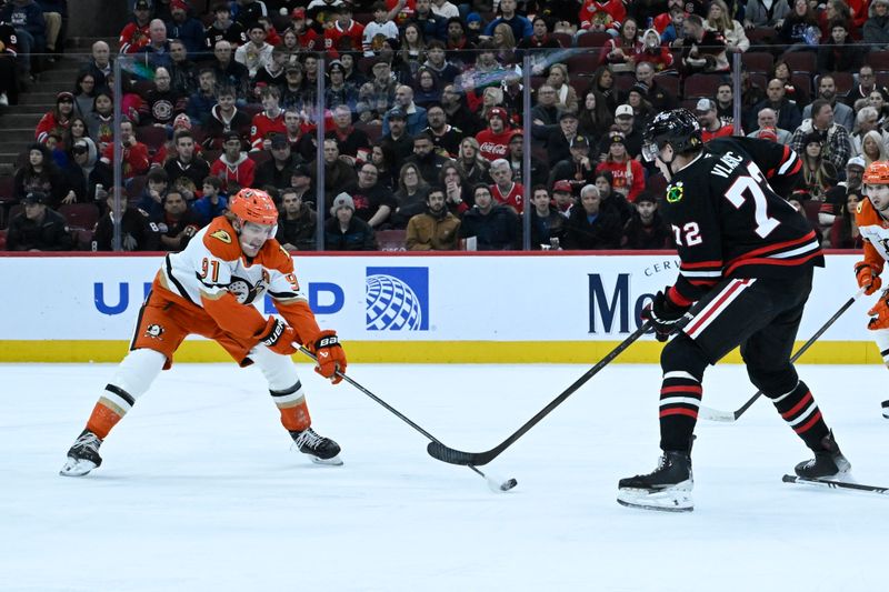 Nov 30, 2025; Chicago, Illinois, USA;  Anaheim Ducks center Leo Carlsson (91) and Chicago Blackhawks defenseman Alex Vlasic (72) chase the puck during the first period at United Center. Mandatory Credit: Matt Marton-Imagn Images