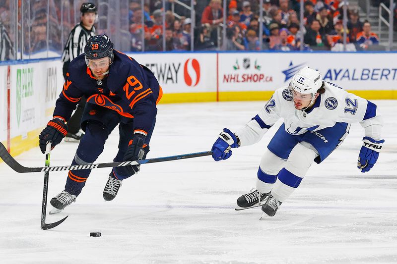 Dec 14, 2023; Edmonton, Alberta, CAN; Edmonton Oilers forward Leon Draisaitl (29) tries to carry the puck around Tampa Bay Lightning forward Alex Barre-Boulet (12) during the third period at Rogers Place. Mandatory Credit: Perry Nelson-USA TODAY Sports