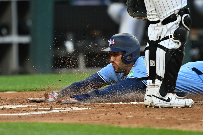May 28, 2024; Chicago, Illinois, USA;  Toronto Blue Jays outfielder George Springer (4) slides across home plate for a run in the second inning against the Chicago White Sox at Guaranteed Rate Field. Mandatory Credit: Jamie Sabau-USA TODAY Sports