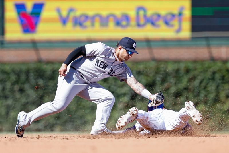 Sep 7, 2024; Chicago, Illinois, USA; Chicago Cubs second baseman Nico Hoerner (2) is caught stealing second base by New York Yankees second baseman Gleyber Torres (25) during the fourth inning at Wrigley Field. Mandatory Credit: Kamil Krzaczynski-Imagn Images