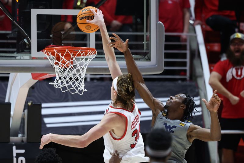 Mar 4, 2025; Salt Lake City, Utah, USA; Utah Utes center Lawson Lovering (34) goes for a dunk against West Virginia Mountaineers guard Toby Okani (5) during the first half at Jon M. Huntsman Center. Mandatory Credit: Rob Gray-Imagn Images