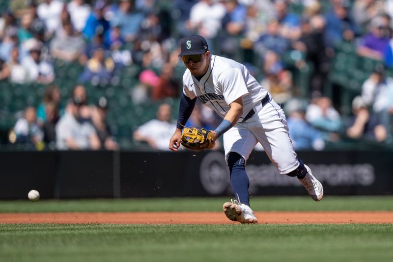 Apr 17, 2024; Seattle, Washington, USA; Seattle Mariners third baseman Luis Urias (16) fields a ground ball during the third inning against the Cincinnati Reds at T-Mobile Park. Mandatory Credit: Stephen Brashear-USA TODAY Sports