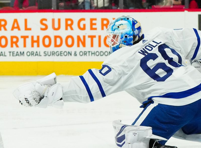 Mar 24, 2024; Raleigh, North Carolina, USA;  Toronto Maple Leafs goaltender Joseph Woll (60) makes a glove save against the Carolina Hurricanes during the first period at PNC Arena. Mandatory Credit: James Guillory-USA TODAY Sports