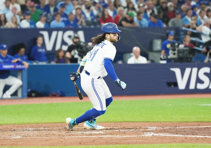 Jun 28, 2023; Toronto, Ontario, CAN; Toronto Blue Jays shortstop Bo Bichette (11) gets on first base on a fielders choice against the San Francisco Giants during the seventh inning at Rogers Centre. Mandatory Credit: Nick Turchiaro-USA TODAY Sports