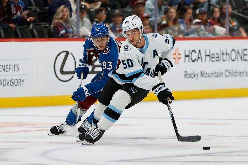Sep 21, 2025; Denver, Colorado, USA; Utah Mammoth defenseman Sean Durzi (50) controls the puck under pressure from Colorado Avalanche center Zakhar Bardakov (93) in the second period at Ball Arena. Mandatory Credit: Isaiah J. Downing-Imagn Images