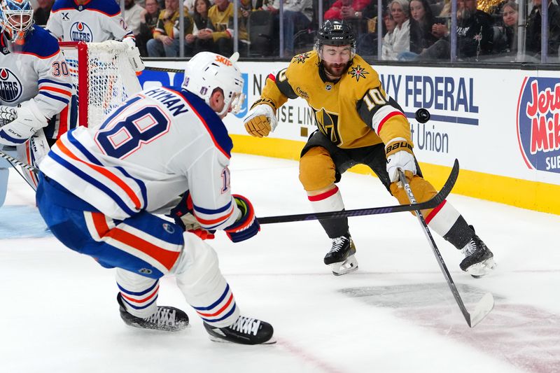 May 6, 2025; Las Vegas, Nevada, USA; Vegas Golden Knights center Nicolas Roy (10) deflects an attempted clear by Edmonton Oilers left wing Zach Hyman (18) during the second period of game one of the second round of the 2025 Stanley Cup Playoffs at T-Mobile Arena. Mandatory Credit: Stephen R. Sylvanie-Imagn Images