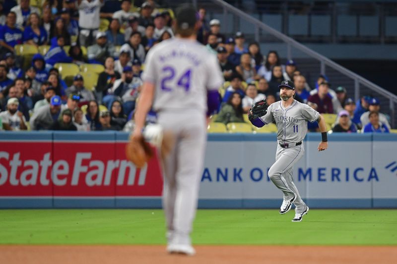 May 31, 2024; Los Angeles, California, USA; Colorado Rockies left fielder Jake Cave (11) catches the fly ball of Los Angeles Dodgers first baseman Freddie Freeman (5) during the sixth inning at Dodger Stadium. Mandatory Credit: Gary A. Vasquez-USA TODAY Sports