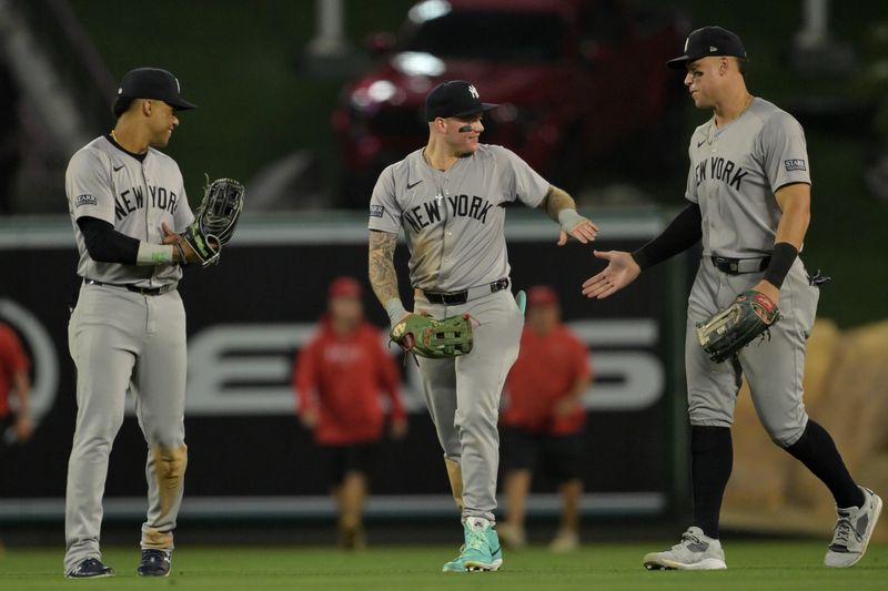 May 30, 2024; Anaheim, California, USA;  New York Yankees right fielder Juan Soto (22), left fielder Alex Verdugo (24) and center fielder Aaron Judge (99) celebrate after the final out of the ninth inning defeating the Los Angeles Angels at Angel Stadium. Mandatory Credit: Jayne Kamin-Oncea-USA TODAY Sports