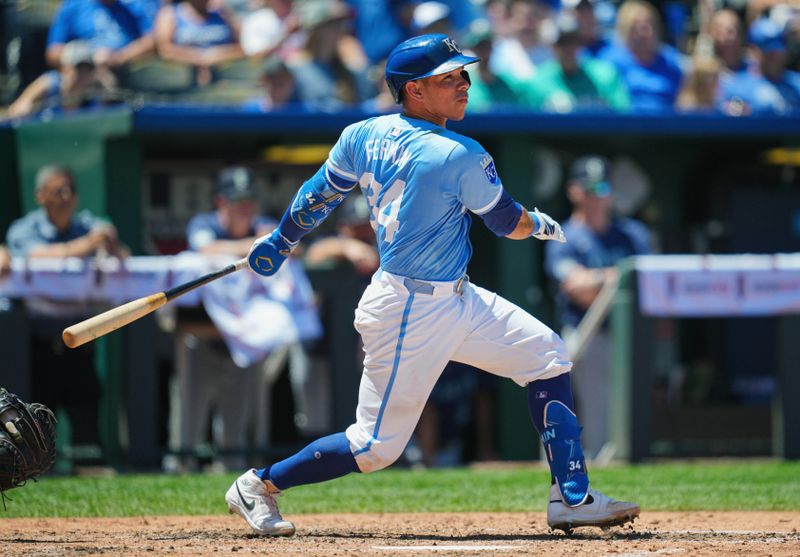 Jun 9, 2024; Kansas City, Missouri, USA; Kansas City Royals catcher Freddy Fermin (34) hits a single during the fifth inning against the Seattle Mariners at Kauffman Stadium. Mandatory Credit: Jay Biggerstaff-USA TODAY Sports