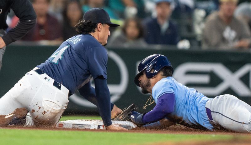 Aug 26, 2024; Seattle, Washington, USA; Tampa Bay Rays third baseman Jose Caballero (7), right, steals second base ahead of a tag by Seattle Mariners third baseman Josh Rojas (4) during the fifth inning at T-Mobile Park. Mandatory Credit: Stephen Brashear-USA TODAY Sports