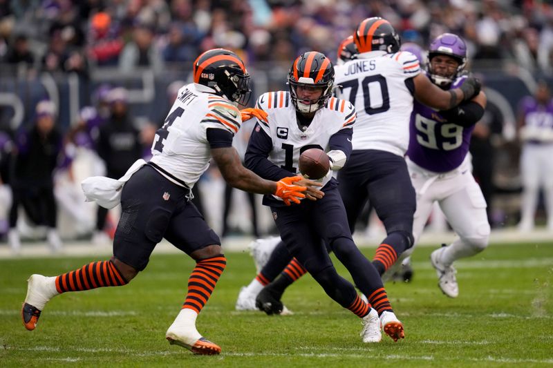 Chicago Bears quarterback Caleb Williams (18) hands off to running back D'Andre Swift (4) during the second half of an NFL football game against the Minnesota Vikings, Sunday, Nov. 24, 2024, in Chicago. (AP Photo/Erin Hooley)