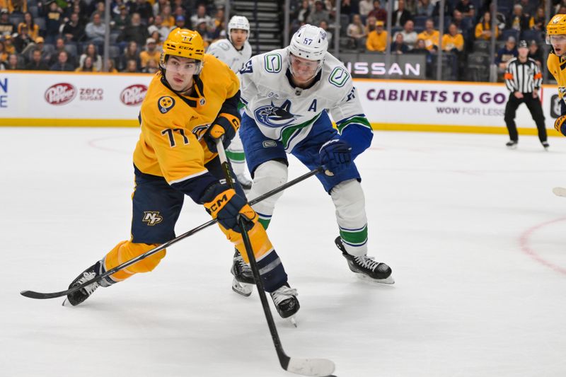 Oct 23, 2025; Nashville, Tennessee, USA;  Nashville Predators right wing Luke Evangelista (77) and Vancouver Canucks defenseman Tyler Myers (57) battle for the puck during the third period at Bridgestone Arena. Mandatory Credit: Steve Roberts-Imagn Images