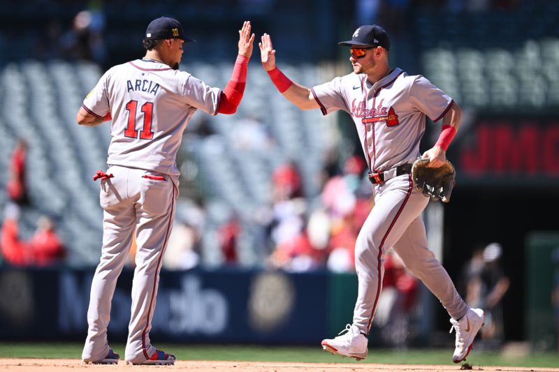 Aug 18, 2024; Anaheim, California, USA; Atlanta Braves shortstop Orlando Arcia (11) high fives outfielder Jarred Kelenic (24) after defeating the Los Angeles Angels during the ninth inning at Angel Stadium. Mandatory Credit: Jonathan Hui-USA TODAY Sports