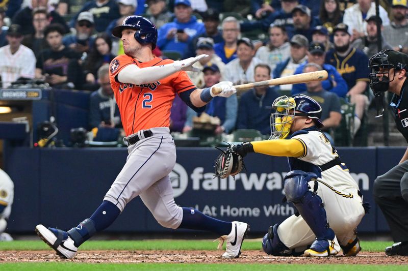 May 24, 2023; Milwaukee, Wisconsin, USA; Houston Astros third baseman Alex Bregman (2) hits a double in the sixth inning while Milwaukee Brewers catcher William Contreras (24) watches at American Family Field. Mandatory Credit: Benny Sieu-USA TODAY Sports