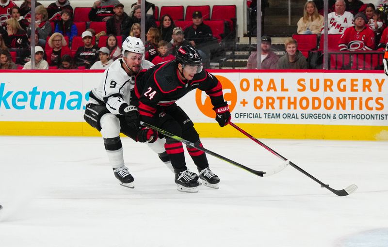 Jan 15, 2024; Raleigh, North Carolina, USA; Los Angeles Kings right wing Adrian Kempe (9) pokes the puck away from Carolina Hurricanes center Seth Jarvis (24) during the third period at PNC Arena. Mandatory Credit: James Guillory-USA TODAY Sports