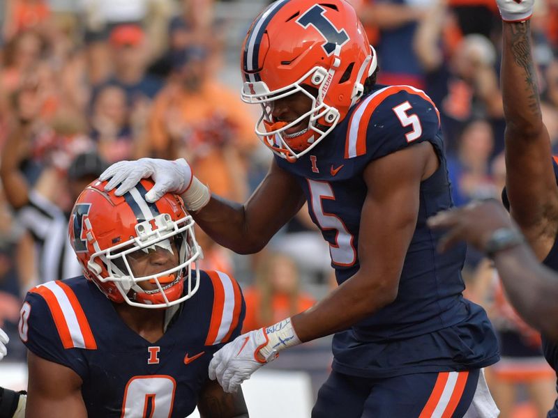 Sep 23, 2023; Champaign, Illinois, USA;  Illinois Fighting Illini defensive back Nicario Harper (0) gets a hand from teammate  Zachary Tobe (5)during the second half at Memorial Stadium. Mandatory Credit: Ron Johnson-USA TODAY Sports