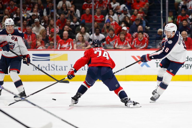 Nov 2, 2024; Washington, District of Columbia, USA; Columbus Blue Jackets defenseman Zach Werenski (8) shoots the puck as Washington Capitals defenseman John Carlson (74) defends in the second period at Capital One Arena. Mandatory Credit: Geoff Burke-Imagn Images