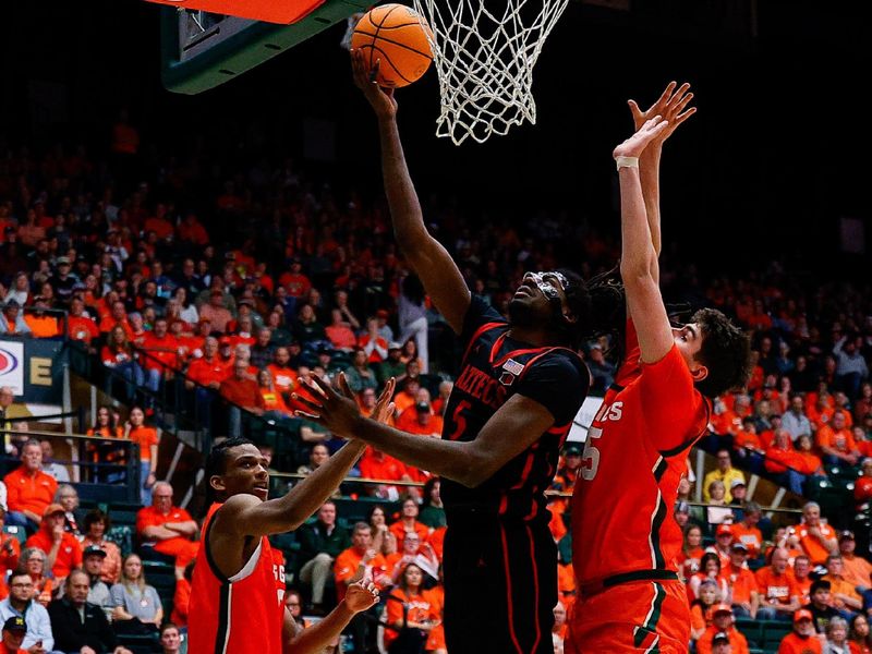 Feb 21, 2026; Fort Collins, Colorado, USA; San Diego State Aztecs forward Pharaoh Compton (5) drives to the basket against Colorado State Rams forward Kyle Jorgensen (35) and forward Carey Booth (0) in the first half at Moby Arena. Mandatory Credit: Isaiah J. Downing-Imagn Images