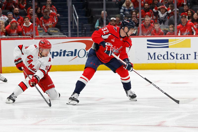 Jan 5, 2024; Washington, District of Columbia, USA; Washington Capitals center Evgeny Kuznetsov (92) skates with the puck as Carolina Hurricanes center Jack Drury (18) defends in the first period at Capital One Arena. Mandatory Credit: Geoff Burke-USA TODAY Sports