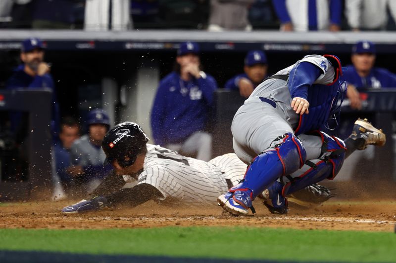 Oct 29, 2024; Bronx, New York, USA; New York Yankees shortstop Anthony Volpe (11) slides safely in front of the tag against Los Angeles Dodgers catcher Will Smith (16) in the eighth inning during game four of the 2024 MLB World Series at Yankee Stadium. Mandatory Credit: Vincent Carchietta-Imagn Images