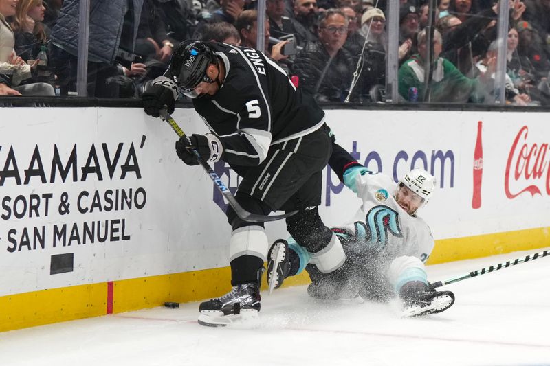 Dec 20, 2023; Los Angeles, California, USA; LA Kings defenseman Andreas Englund (5) and Seattle Kraken right wing Oliver Bjorkstrand (22) battle for the puck in the third period at Crypto.com Arena. Mandatory Credit: Kirby Lee-USA TODAY Sports