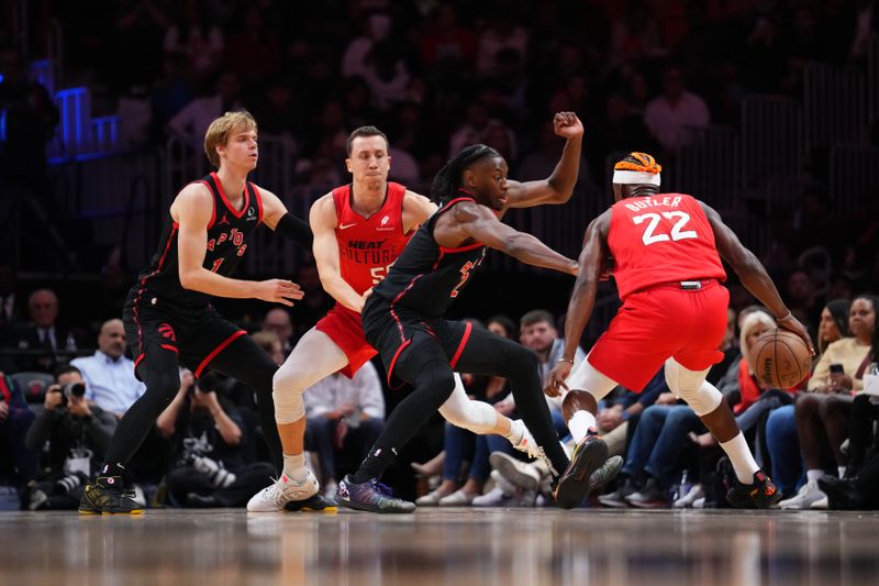 MIAMI, FLORIDA - DECEMBER 12: Jimmy Butler #22 of the Miami Heat dribbles the ball against Jonathan Mogbo #2 of the Toronto Raptors during the third quarter at Kaseya Center on December 12, 2024 in Miami, Florida. NOTE TO USER: User expressly acknowledges and agrees that, by downloading and or using this Photograph, user is consenting to the terms and conditions of the Getty Images License Agreement. (Photo by Rich Storry/Getty Images)