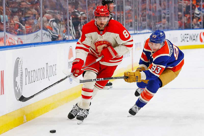 Feb 24, 2024; Edmonton, Alberta, CAN; Calgary Flames defensemen Chris Tanev (8) protects the puck from Edmonton Oilers forward Ryan Nugent-Hopkins (93) during the second period at Rogers Place. Mandatory Credit: Perry Nelson-USA TODAY Sports