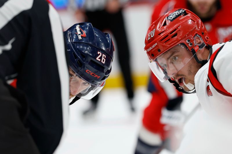 May 6, 2025; Washington, District of Columbia, USA; Washington Capitals center Nic Dowd (26) and Carolina Hurricanes center Sebastian Aho (20) prepare to take a face-off in the second period in game one of the second round of the 2025 Stanley Cup Playoffs at Capital One Arena. Mandatory Credit: Geoff Burke-Imagn Images