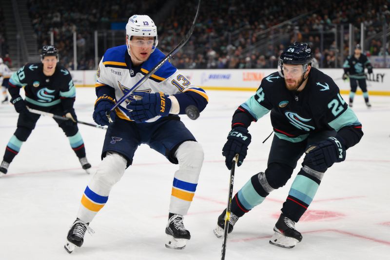 Jan 26, 2024; Seattle, Washington, USA; St. Louis Blues right wing Alexey Toropchenko (13) and Seattle Kraken defenseman Jamie Oleksiak (24) play the puck during the first period at Climate Pledge Arena. Mandatory Credit: Steven Bisig-USA TODAY Sports