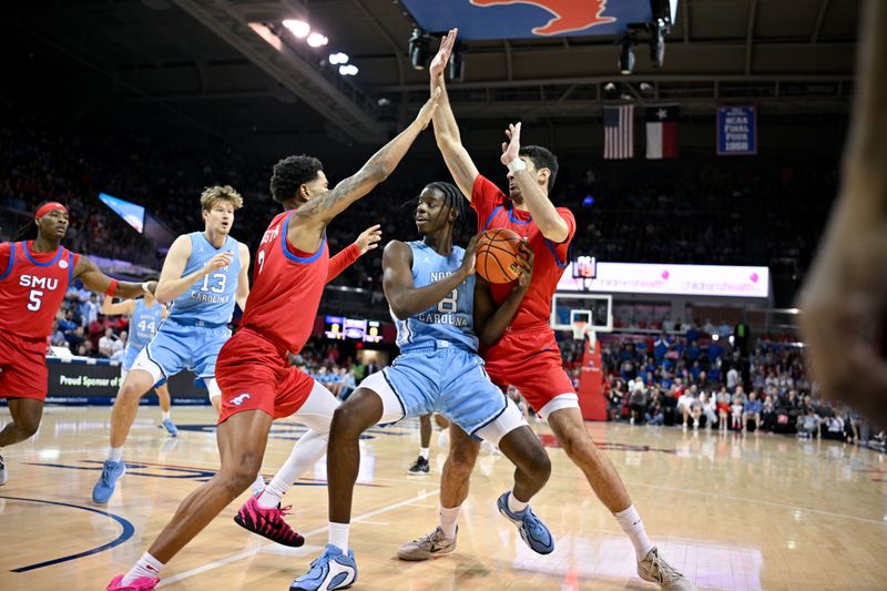 Jan 3, 2026; Dallas, Texas, USA; North Carolina Tar Heels forward Caleb Wilson (8) moves the ball to the basket past SMU Mustangs forward Corey Washington (3) and center Samet Yigitoglu (24) during the first half at Moody Coliseum. Mandatory Credit: Jerome Miron-Imagn Images
