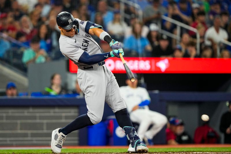 Jun 29, 2024; Toronto, Ontario, CAN; New York Yankees outfielder Aaron Judge (99) hits a RBI single against the Toronto Blue Jays during the fifth inning at Rogers Centre. Mandatory Credit: Kevin Sousa-USA TODAY Sports