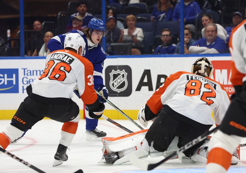 Nov 7, 2024; Tampa, Florida, USA; Tampa Bay Lightning center Conor Geekie (14) shoots as Philadelphia Flyers defenseman Emil Andrae (36) and goaltender Ivan Fedotov (82) defend during the first period at Amalie Arena. Mandatory Credit: Kim Klement Neitzel-Imagn Images