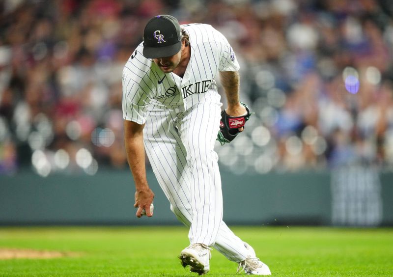 Sep 28, 2023; Denver, Colorado, USA; Colorado Rockies relief pitcher Connor Seabold (43) reaches for the ball in the ninth inning against the Los Angeles Dodgers at Coors Field. Mandatory Credit: Ron Chenoy-USA TODAY Sports