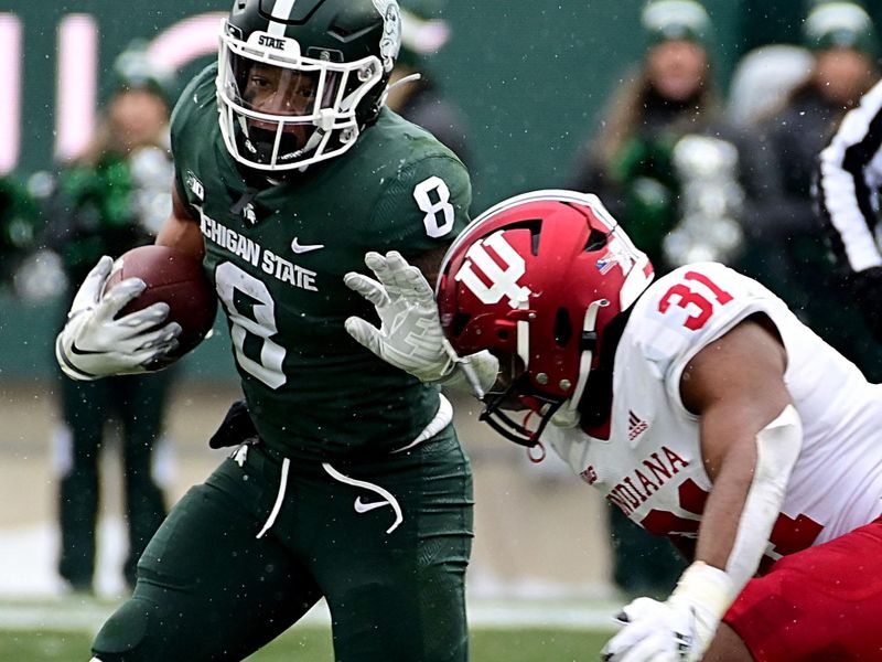 Nov 19, 2022; East Lansing, Michigan, USA;  Michigan State Spartans running back Jalen Berger (8) stiff-arms Indiana Hoosiers defensive back Bryant Fitzgerald (31) in the fourth quarter at Spartan Stadium. Mandatory Credit: Dale Young-USA TODAY Sports