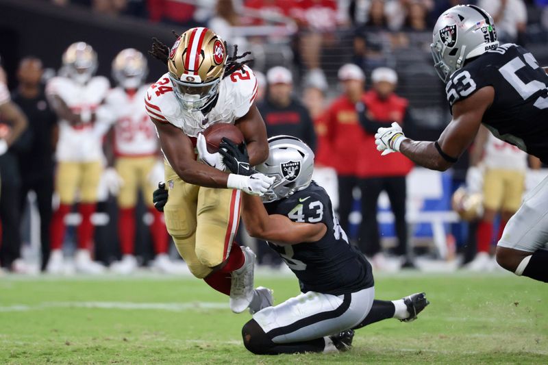 Las Vegas Raiders linebacker Kana'i Mauga (43) tackles San Francisco 49ers running back Jordan Mason (24) during the first half of an NFL preseason football game, Friday, Aug. 23, 2024, in Las Vegas. (AP Photo/Ian Maule)