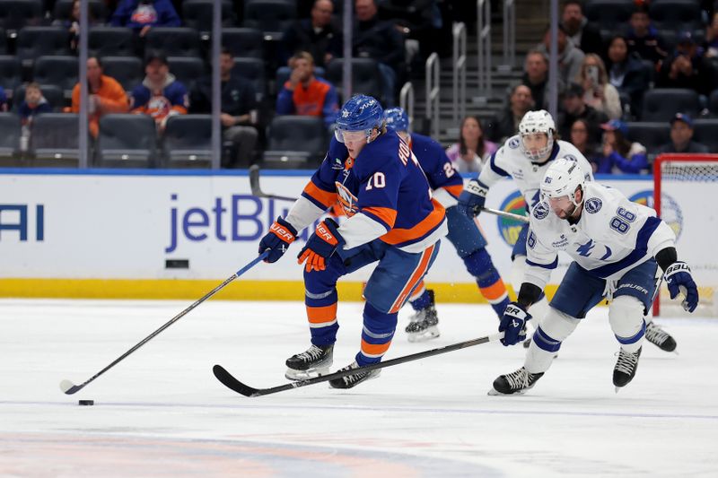 Dec 2, 2025; Elmont, New York, USA; New York Islanders right wing Simon Holmstrom (10) skates with the puck against Tampa Bay Lightning right wing Nikita Kucherov (86) during the second period at UBS Arena. Mandatory Credit: Brad Penner-Imagn Images