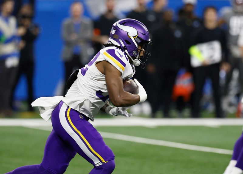 Minnesota Vikings running back Ty Chandler carries the ball against the Detroit Lions during the first half of an NFL football game Sunday, Jan. 7, 2024, in Detroit. (AP Photo/Duane Burleson)