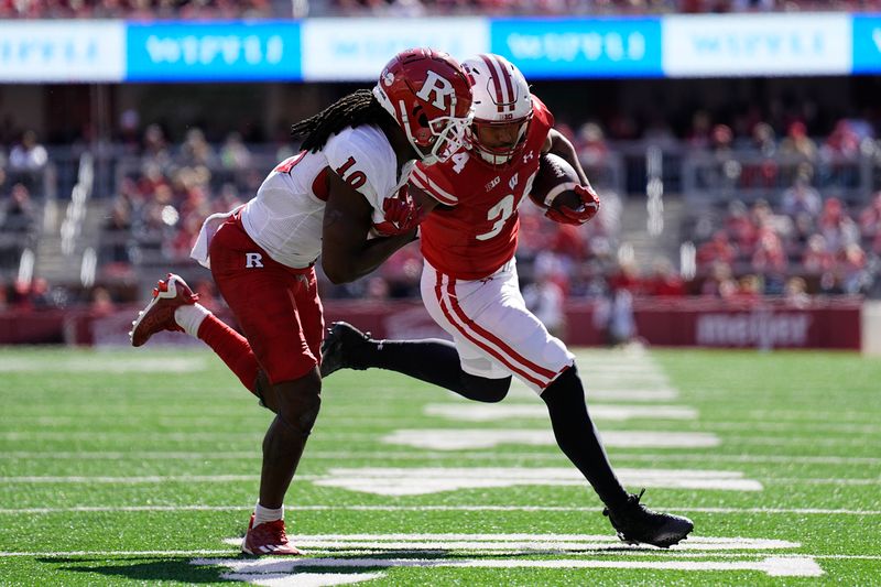 Oct 7, 2023; Madison, Wisconsin, USA;  Rutgers Scarlet Knights defensive back Flip Dixon (10) tackles Wisconsin Badgers running back Jackson Acker (34) during the fourth quarter at Camp Randall Stadium. Mandatory Credit: Jeff Hanisch-USA TODAY Sports